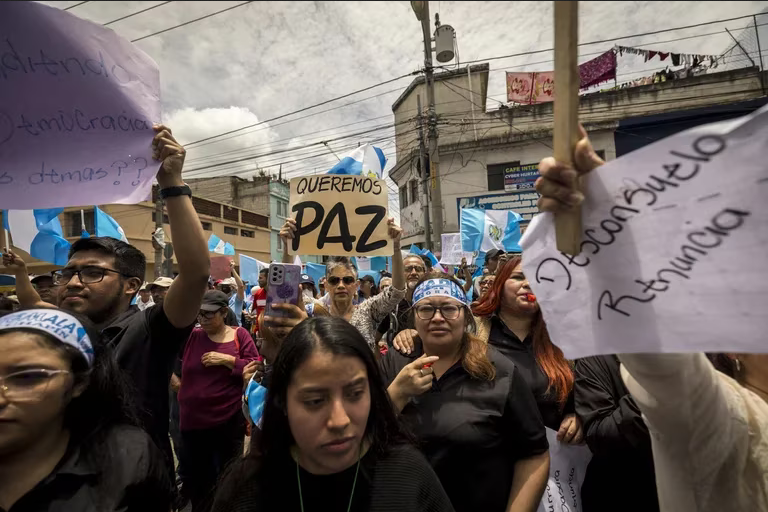 Manifestantes sostienen carteles durante una protesta frente a la sede del Ministerio Público en Ciudad de Guatemala por las acciones en contra del presidente electo Bernardo Arévalo