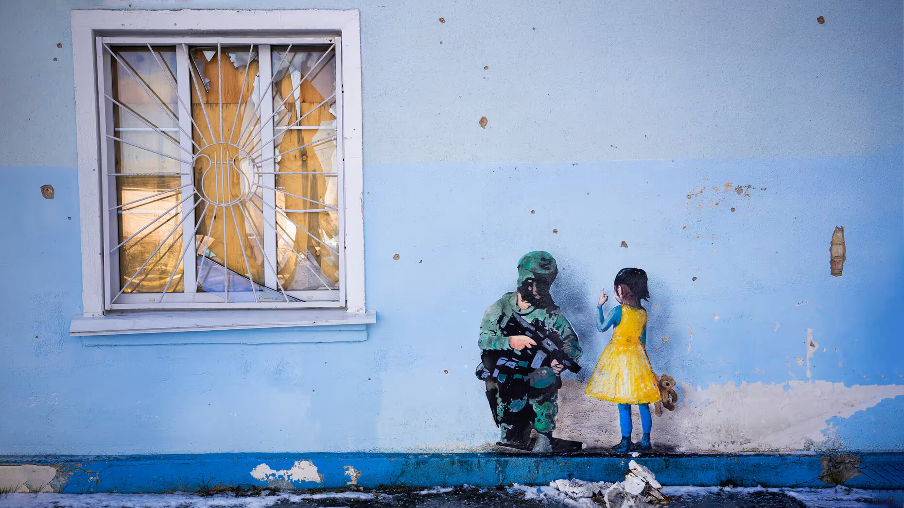 Grafiti en que una niña vestida con los colores de la bandera de Ucrania confronta a un soldado ruso.