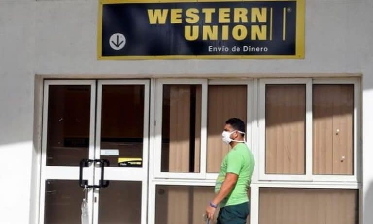 Una persona camina frente a una sucursal de Western Union.