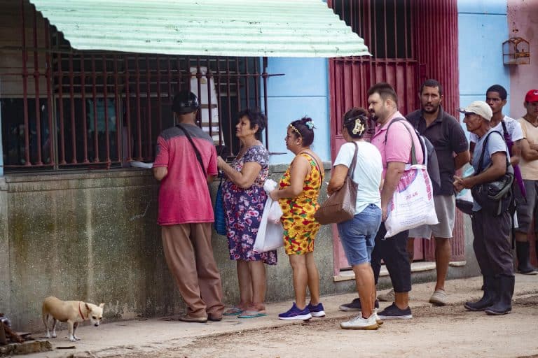 Varias personas hacen fila para comprar alimentos en un negocio en un pueblo de Mayabeque, Cuba.