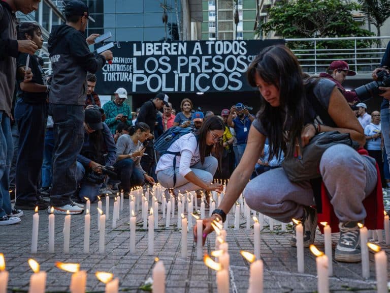 Personas prenden velas durante una vigilia nacional por los presos políticos en Venezuela.