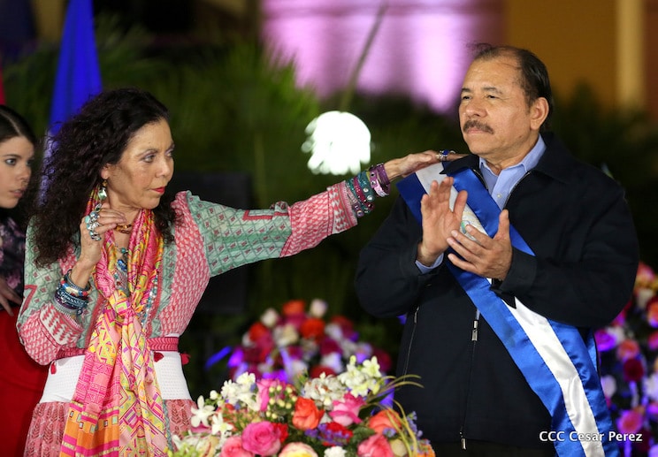 Rosario Murillo acomoda la banda presidencial a su esposo, Daniel Ortega.