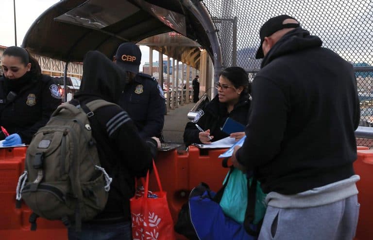 Migrantes hacen fila para cruzar la frontera hacia Estados Unidos en el Puente Internacional Paso del Norte, en Ciudad Juárez.