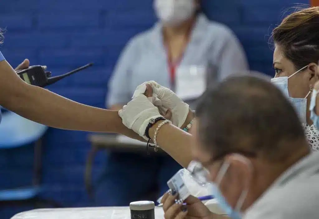 A member of the Vote Receiving Board cleans the finger of a citizen, during the municipal votes, on November 6, 2022, at the Salvador Mendieta school in Managua.