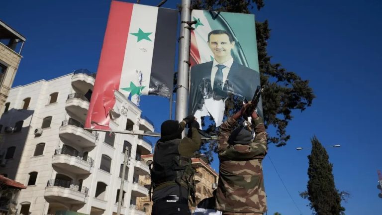 Combatientes de la oposición siria rompen un retrato del presidente sirio Bashar al Asad.