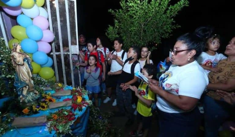 Pobladores de Managua cantan frente a un altar a la Purísima.