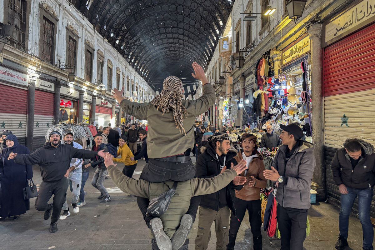 Personas bailan y dan muestras de alegría en el zoco de Al Hamidiya, el más grande de la capital siria.